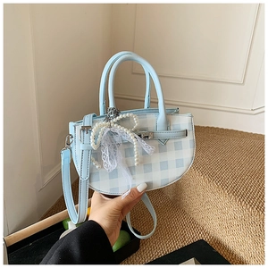 Detail of light blue plaid bucket bag with pearl bow charm and lace ribbon handle