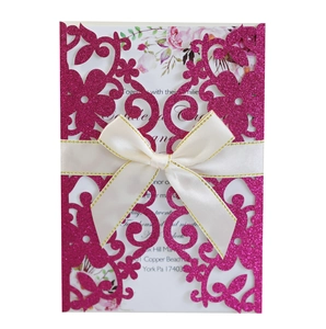 Dettaglio dell'invito di nozze intagliato al laser con copertina glitter rosa e fiocco crema
