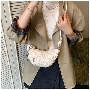 Détail du sac demi-lune plissé blanc avec bandoulière nouée et chaîne dorée