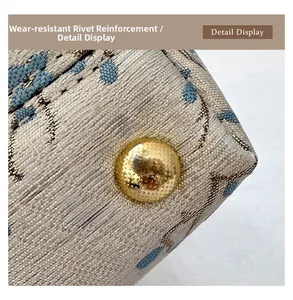 Detail view of durable gold metal stud reinforcement on jacquard fabric handbag base