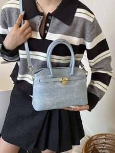 Chic light blue denim bucket bag with gold padlock detail and top handles for women