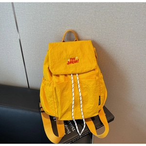 Detail of light yellow nylon backpack with You Jibear embroidery and drawstring closure