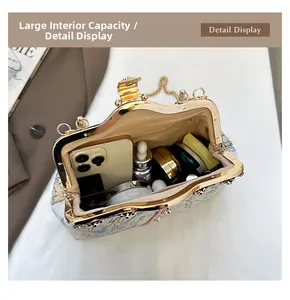 Detail view of the spacious inner compartment with flower embroidery and metal frame