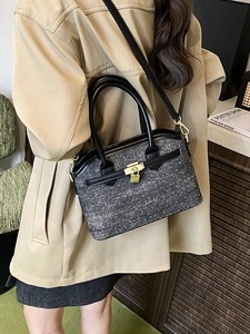 Grey textured fabric bucket bag with black leather handle and golden metal lock