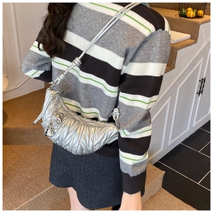 Détail du sac croissant argenté métallisé avec texture plissée et chaîne décorative
