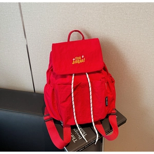 Detail of red backpack flap with yellow You JIBEAR embroidery and drawstring closure
