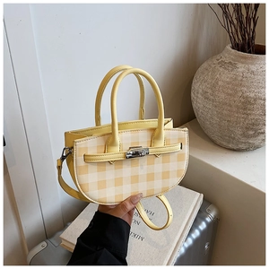 Close-up of a yellow gingham bucket bag with a silver metal twist lock and dual handles