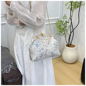 Macro detail of Chinese retro bag with blue floral embroidery and pearl chain
