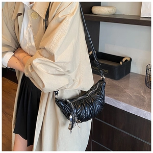 Détail du sac croissant plissé noir avec texture matelassée et pendentif chaîne argent