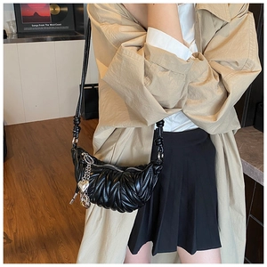 Détail du sac hobo matelassé noir avec chaîne coeur argentée et texture plissée