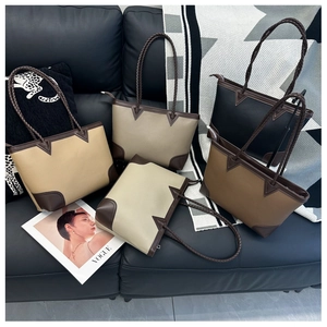 Detailed view of color-block leather tote bags with woven handles and reinforced base