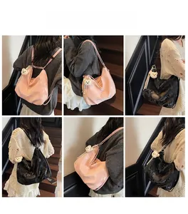 Dettagli delle borse tote in raso rosa e nero con ciondoli a forma di orsetto di peluche