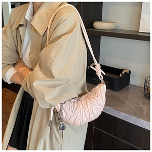 Vue détaillée d'un sac matelassé rose en forme de lune avec chaîne argentée et cadenas