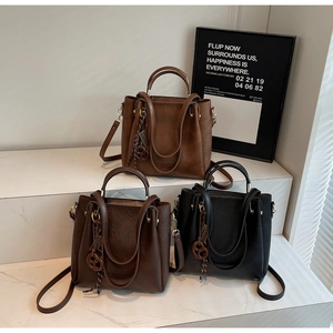Chic retro bucket bags in black and brown finishes featuring woven logo charms