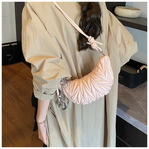 Vue détaillée du sac demi-lune rose matelassé avec surpiqûres et breloque argent