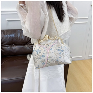 Detail of floral embroidery, pearl accents and vintage gold flower clasp on handbag