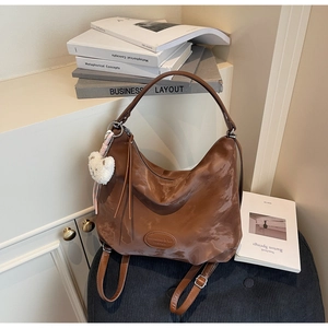 Vista dettagliata della borsa tote marrone increspata con charm a forma di orso