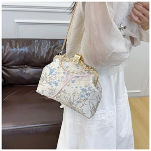 Detail of vintage floral jacquard kiss-lock bag with pearl accents and gold metal handle