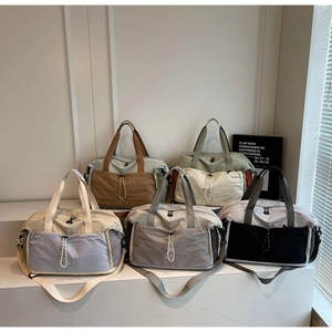 Detail of expandable nylon travel bags in five colors with functional pockets and straps