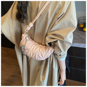 Détail du sac hobo plissé rose avec pendentif coeur argenté et bandoulière à nœuds