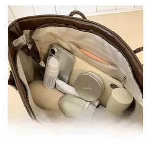 Detailed view of spacious interior with herringbone lining and zippered pocket of the tote bag