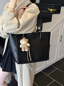 Large black woven tote bag for women featuring a cute plush bear charm on shoulder strap