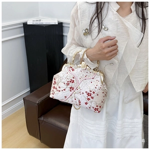 Close-up of plum blossom embroidery and pearl details on retro frame handbag