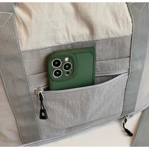 Detailed view of large travel bag showing front zipper pocket with smartphone storage space