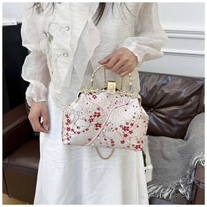 Close-up of Chinese style embroidery handbag with bamboo handle and pearl accents