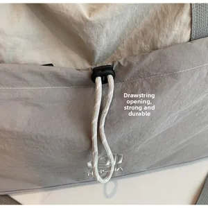 Detail of drawstring opening on travel bag with durable nylon fabric and logo embroidery