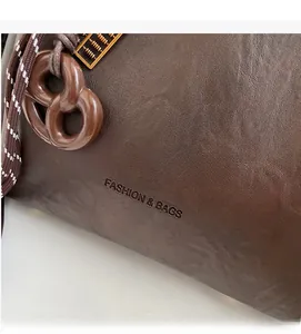 Detail of dark brown leather texture with golden abacus charm and braided drawstring
