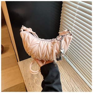 Détail d'un sac hobo plissé rose clair avec texture en cuir matelassé et bijou de sac