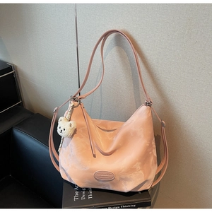Dettaglio borsa hobo rosa con motivo marmorizzato e ciondolo a forma di orsetto