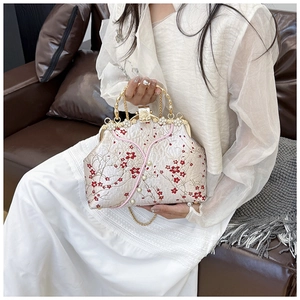 Detail of vintage Chinese embroidery bag with red plum blossoms and pearl clasp
