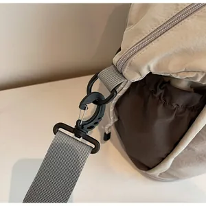 Close-up of durable black swivel hook and high-density grey shoulder strap on travel bag