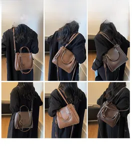Detail view of retro leather bucket bag with fringe and metal trim in brown and caramel