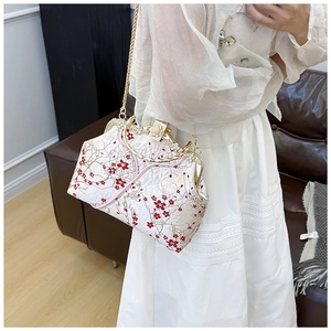 Close-up of vintage white cheongsam bag with red plum embroidery and gold chain strap