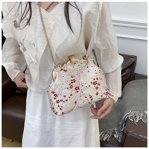 Macro shot of embroidered floral fabric and pearl encrusted metal clasp on evening bag