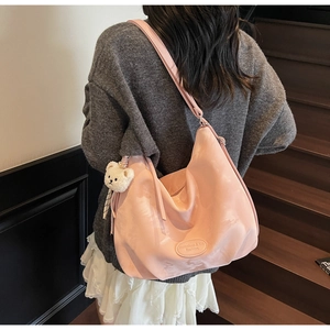 Grande borsa tote rosa a pieghe con portachiavi a orsetto bianco portata da modella