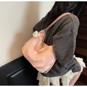 Dettaglio della borsa tote in nylon pieghettato rosa con ciondolo a forma di orso