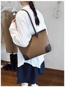 Detail of contrast stitch tote bag with woven shoulder straps and pebble leather texture