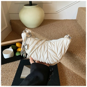 Détail du sac hobo matelassé blanc cassé avec pendentif cœur et boucles argentées