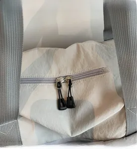 Detailed macro view of high-quality smooth two-way zippers on travel duffel bag