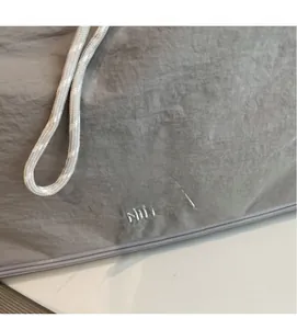 Close-up of NINGJIA logo embroidery on gray travel bag fabric with zipper detail