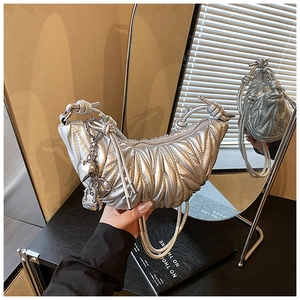 Détail du sac croissant argenté plissé avec charms de chaîne en forme de cœur et cadenas