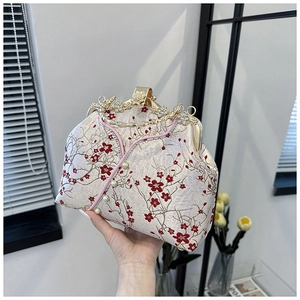 Macro detail of red plum blossom embroidery and rhinestone flower clasp on Cheongsam bag