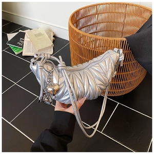 Détail du sac hobo plissé argenté métallisé avec charmes en cœur sur la lanière