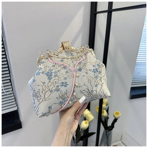 Detail of cream brocade cheongsam bag with blue floral embroidery and pearl button