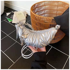 Sac croissant argenté matelassé avec finition métallisée et détail de pendentif cœur