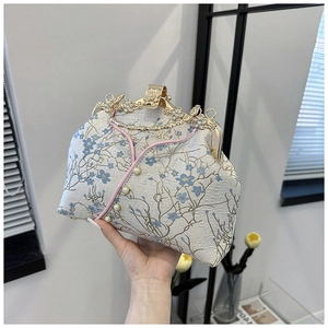 Detail of embroidered cheongsam bag featuring plum blossoms and rhinestone handle